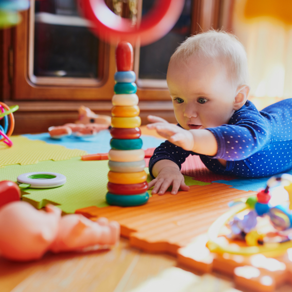Baby playing with colorful toys on the floor