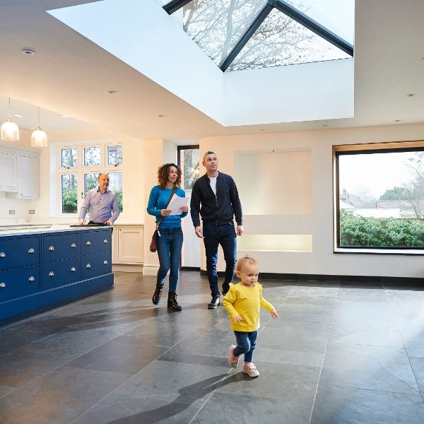 Couple and toddler exploring a new empty home with a realtor