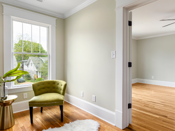 Warm Hardwood floors in a small seating area with a green chair