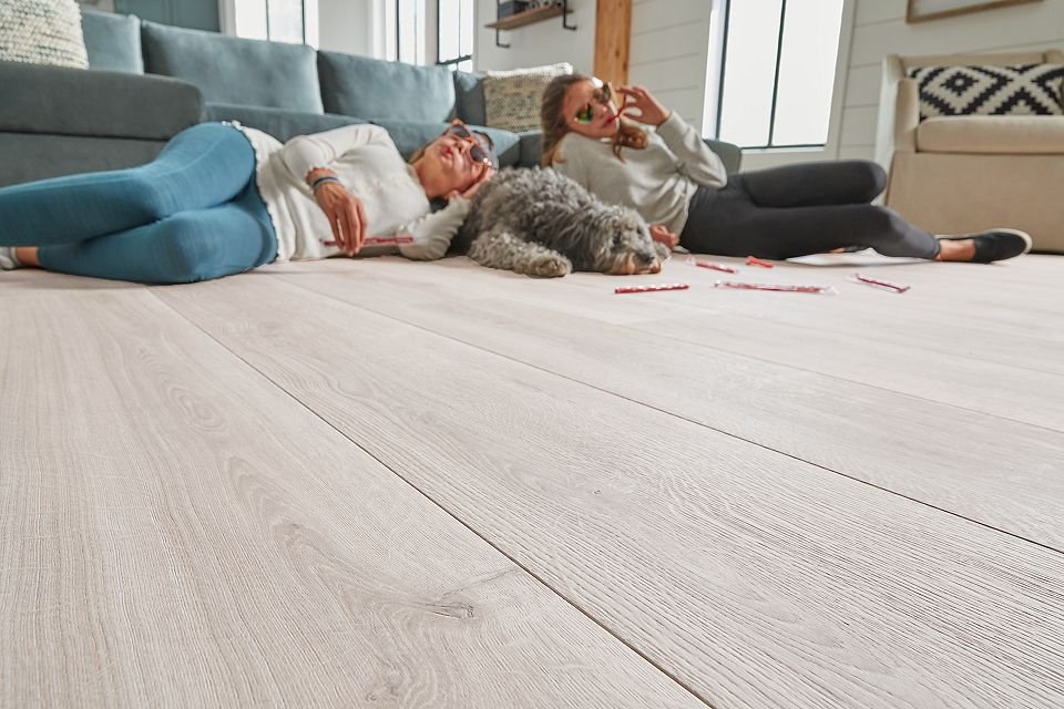 Teenagers laying on RevWood floor with dog